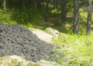Schaumglas von GLAPOR als Schüttgut geschmackvoll präsentiert in einem Wald.