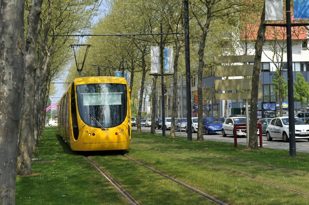 Gelbe Straßenbahn auf Rasengleisen