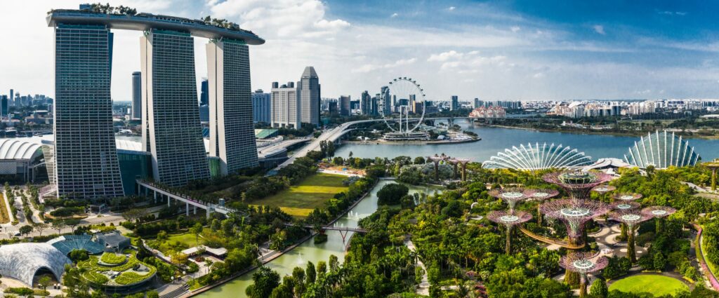 Futuristisch anmutendes Bild von Singapur mit Hochhäusern, Parks, Grünflächen und Wasser.