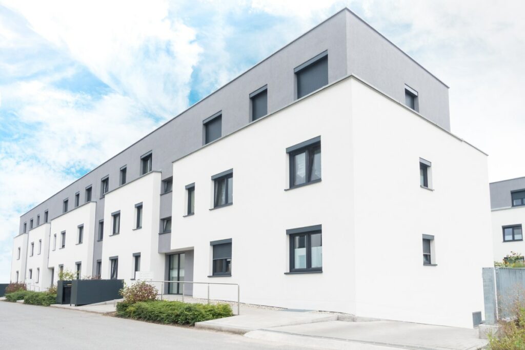 Moderner Neubau eines Mehrfamilienhauses mit mit weißer Fassade